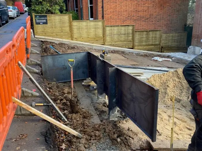 Corten steel wall panels flexing with soil movement, unlike rigid concrete retaining walls that crack and fail during ground shifts.